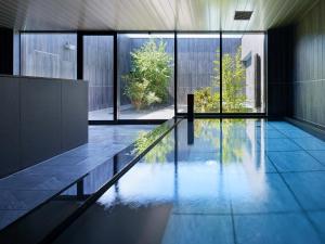 a swimming pool in a house with a large window at Sapporo Granbell Hotel in Sapporo