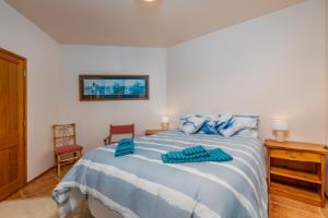 ein Schlafzimmer mit einem Bett mit blauen Kissen darauf in der Unterkunft The Kereru's Nest in Kaeo