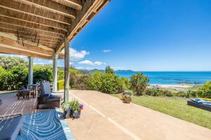 an outdoor patio with a view of the ocean at The Kereru's Nest in Kaeo