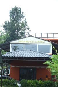 a building with a sign on top of it at Vistar Resort & Hotels in Bangalore