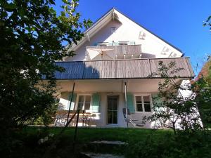 a white house with a balcony on top of it at WÄLDER: Quartier Haus im Glück in St. Blasien
