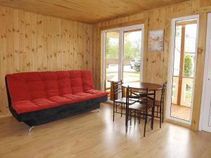 sala de estar con sofá rojo y mesa en Kunigiškių 2, en Palanga