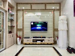 uma sala de estar com uma televisão na parede em 百墅居•漫生活主题民宿 em Luoshan