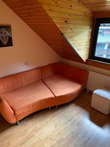 um sofá no canto de um quarto num sótão em Pr Kopač Krvavec em Cerklje na Gorenjskem
