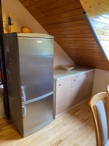 uma cozinha com um frigorífico de aço inoxidável num sótão em Pr Kopač Krvavec em Cerklje na Gorenjskem