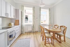 a kitchen with a table and chairs and a kitchen with white cabinets at Lovely, Best View Apartment, Vilnius City Centre in Vilnius
