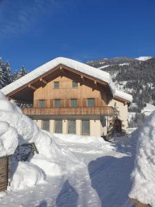 un edificio cubierto de nieve con techo cubierto de nieve en Haus Planegg, en Lainach