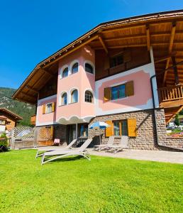 a large house with a green lawn in front of it at Villa Lory in Canazei