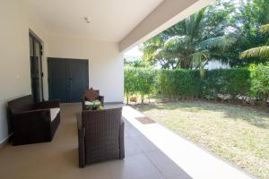 un patio con sillas y vistas a un patio en Two Bedroom Apartment with Garden and Pool Access - Azuri Village, Roches Noires, en Roches Noires