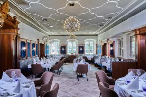 een eetkamer met tafels en stoelen en een kroonluchter bij Hotel Zur Post Altötting in Altötting