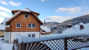a wooden house with snow on a bridge at Appartements Fanny in Sankt Margarethen im Lungau