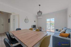 ein Wohnzimmer mit einem Holztisch und einem blauen Sofa in der Unterkunft L'oranger Proche centre ville WIFINETFLIX in Perpignan