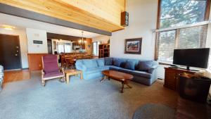 a living room with a blue couch and a tv at Wild Flower 42 Apartment in Mammoth Lakes
