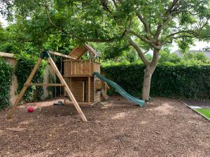 a playground with a slide and a tree at The westhouse in Middelkerke