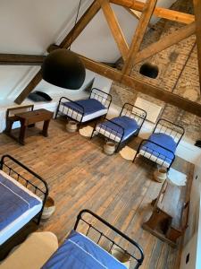 Zimmer mit 4 Betten und Stühlen in einem Gebäude in der Unterkunft The westhouse in Middelkerke