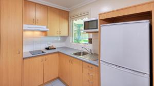 a kitchen with a white refrigerator and a sink at Motel Carnarvon in Roma +58 photos