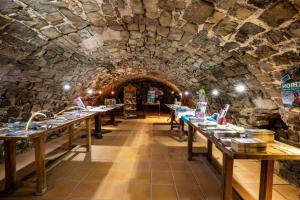 a room with long tables in a stone tunnel at Camping RCN Val de Cantobre in Cantobre