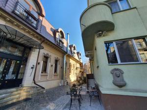 an alley with tables and chairs next to a building at Vila Sia in Bucharest