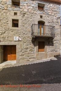 un edificio de piedra con un balcón en un lateral. en Casa Rural El Salon del Baile, en Navarredondilla