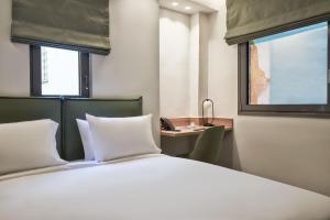 A bed or beds in a room at NLH KERAMEIKOS - Neighborhood Lifestyle Hotels