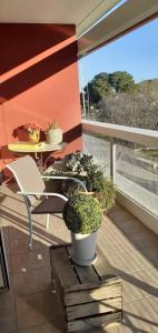 een balkon met een stoel en een tafel met planten bij chez MARINO antony real in Orange