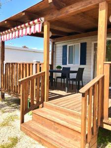 una terrazza in legno con tavolo su una casa di Camping Village Nice Garden ad Ardea