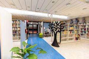 een bibliotheek met een boom in het midden bij Hostel Linnasmäki in Turku