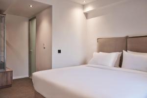 A bed or beds in a room at NLH KERAMEIKOS - Neighborhood Lifestyle Hotels