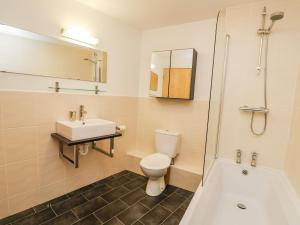 a bathroom with a toilet and a sink and a tub at The Mushroom House in Tenby +11 photos
