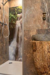 una doccia in bagno con una foto di una cascata di Zirbenchalet Grossglockner a Heiligenblut