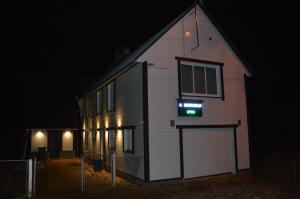 a house with a sign on the side of it at night at Livonia Matkamaja in Kilingi-Nõmme