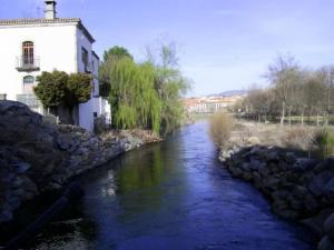 rzeka z budynkiem obok budynku w obiekcie Casa Rural La Central-La Higuerilla w mieście El Barco de Ávila