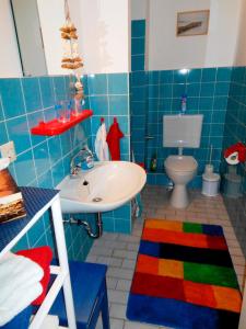 エッカーンフェルデにあるKerstin Dujourの青いタイル張りのバスルーム(洗面台、トイレ付)