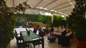 a patio with a table and chairs and a couch at La Peonia Charming Accommodation in Cagliari