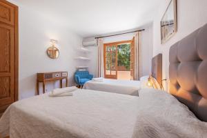 a hotel room with two beds and a window at Villa Ramis by JS Villas in Cala de Sant Vicenc +16 photos