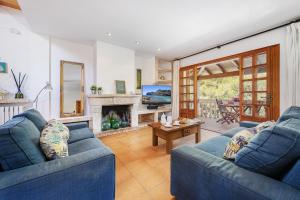a living room with two blue couches and a fireplace at Villa Ramis by JS Villas in Cala de Sant Vicenc