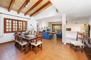 a dining room and living room with a table and chairs at Villa Ramis by JS Villas in Cala de Sant Vicenc