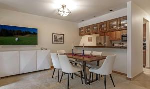 a kitchen and dining room with a table and white chairs at Townsend Place A107 Condo in Beaver Creek