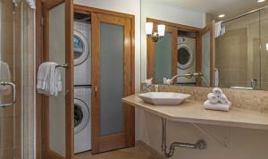 a bathroom with a sink and a washing machine at Townsend Place A107 Condo in Beaver Creek +25 photos