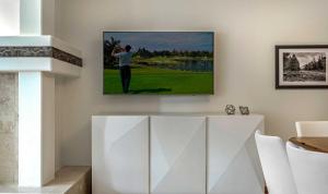 a painting of a golfer hanging on a wall at Townsend Place A107 Condo in Beaver Creek