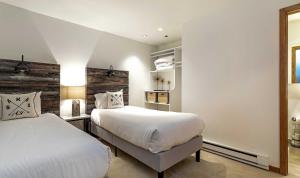 a bedroom with two beds and a headboard at Townsend Place A107 Condo in Beaver Creek