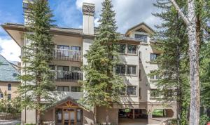 an apartment building with trees in front of it at Townsend Place A107 Condo in Beaver Creek