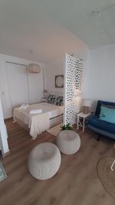a bedroom with a bed and two ottomans at Apartment Fuengirola Carvajal beach front Málaga Spain in Fuengirola