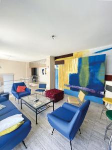 a living room with blue chairs and a painting at Euphorbia Residence in Lecce