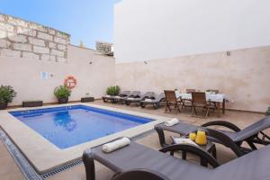 a swimming pool with chairs and a table and a tableasteryasteryasteryasteryastery at Sa Placeta new reformed large town house with pool in Sa Pobla