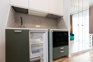 uma cozinha com armários brancos e um frigorífico verde em Cozy apartment Kazimierza 48, Wola em Varsóvia