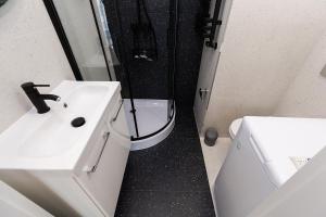 uma casa de banho com um lavatório, um chuveiro e um WC. em Cozy apartment Kazimierza 48, Wola em Varsóvia