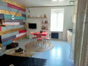 eine Küche mit einem roten Tisch und Stühlen im Zimmer in der Unterkunft L'éléphant Blanc de ConcarnOLoc in Concarneau
