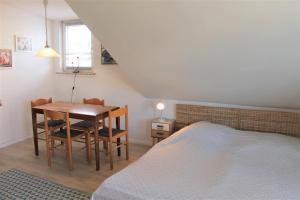 um quarto com uma cama, uma mesa e cadeiras em Haus Barbara - Schwimmbad und Sauna im Haus- Whg 6 em Grömitz