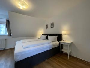 ein Schlafzimmer mit einem großen Bett und einem Nachttisch in der Unterkunft Apartment mit Balkon No4 in Quedlinburg